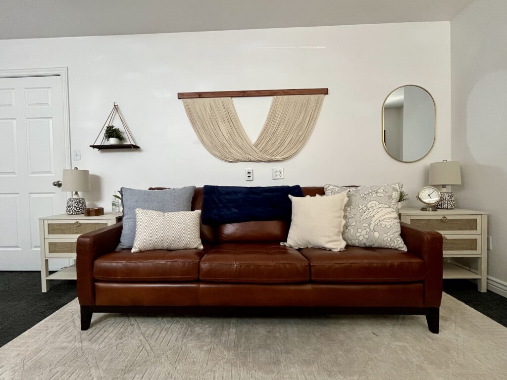 Burgundy couch with pillows against white wall in an office where an EMDR trained therapist works