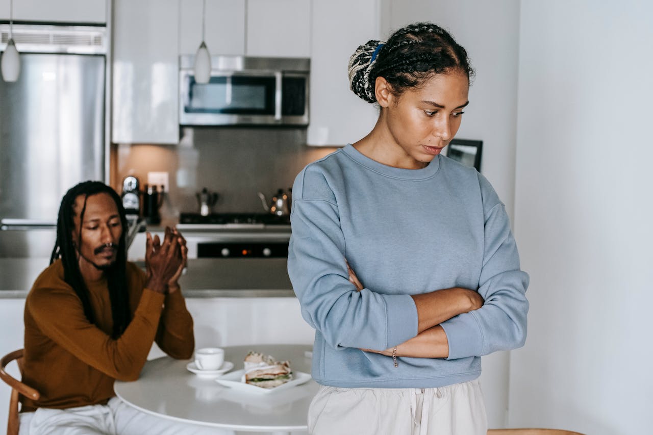 woman, arms folded, facing away from man