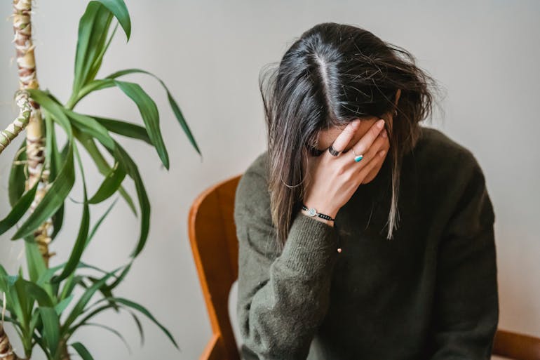 a woman covering her face with her hand needing Northern Utah Counseling