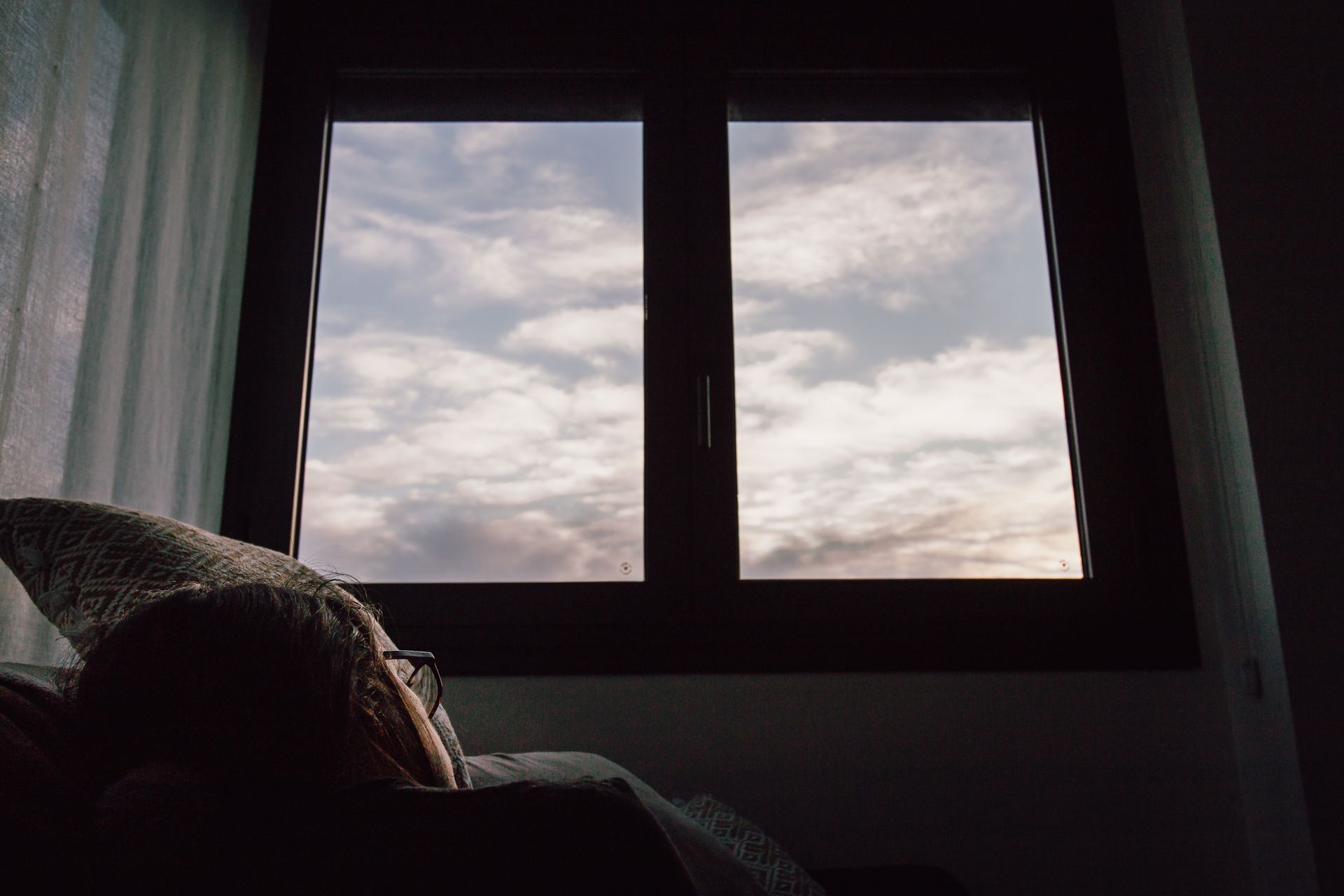 a woman looking through the window and thinking about how avoidance traps you and keeps you stuck